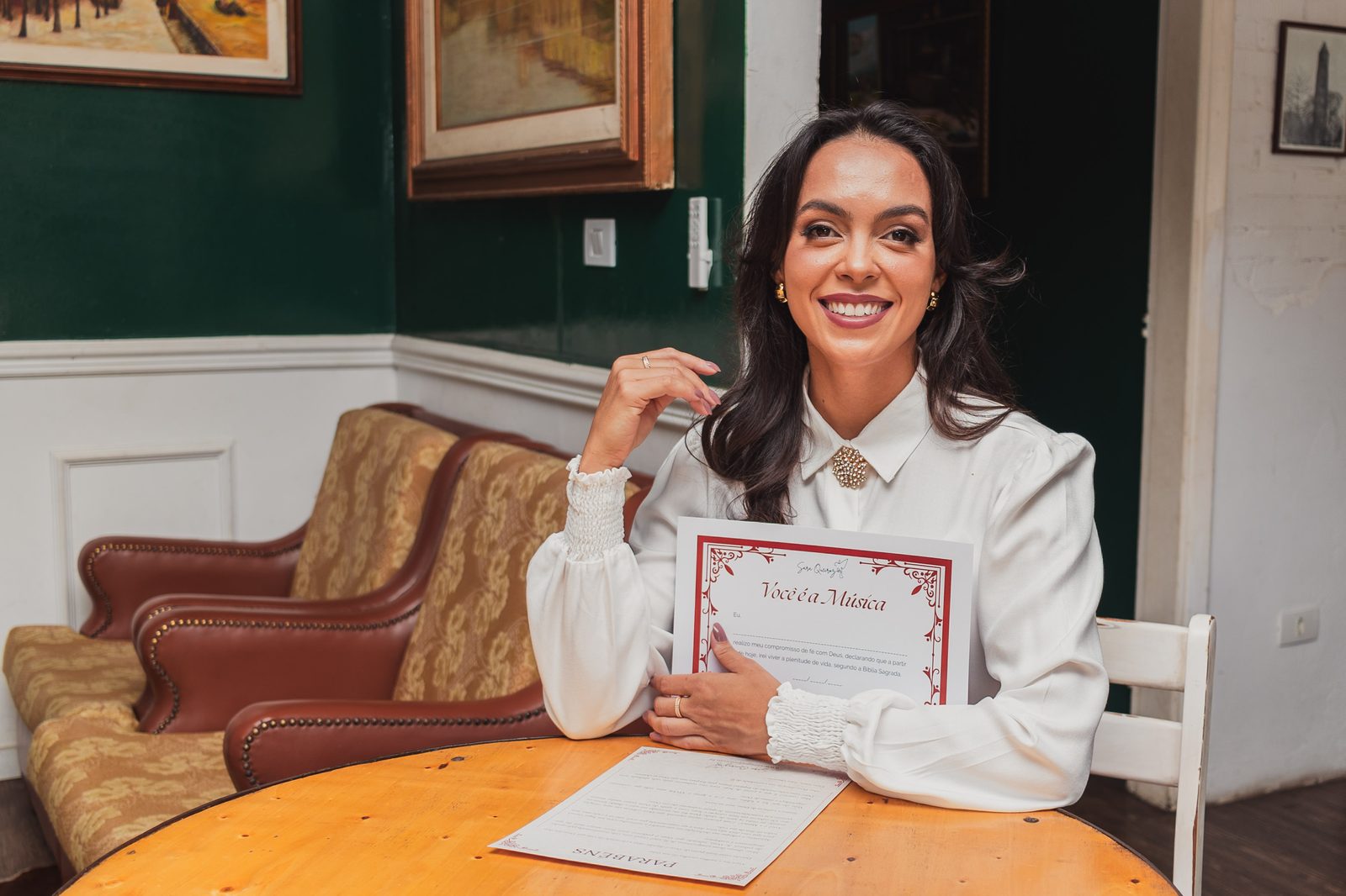 Certificado oficial Você é a Música — segurando o certificado